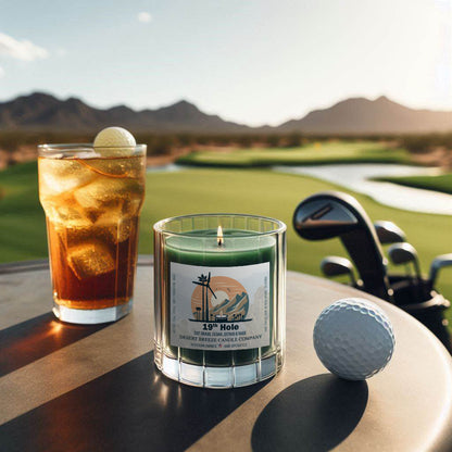 Green canle in clear tumbler overlooking a golf course at sunrise