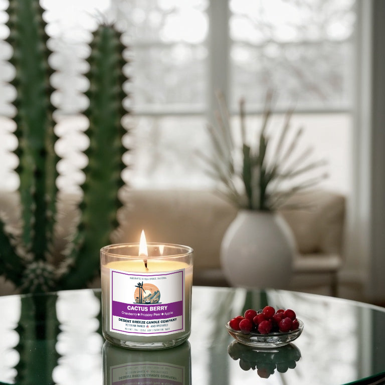 White candle on a table with cactus and cranberries