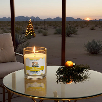 A white candle in clear tumbler sitting on table with desert outside window and a christmas tree